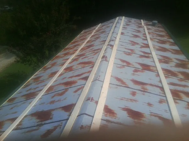 Rusted metal roof panels with new wood purlins before replacement — Storm Damage Roof Repair in Oil City by Roofing Brothers