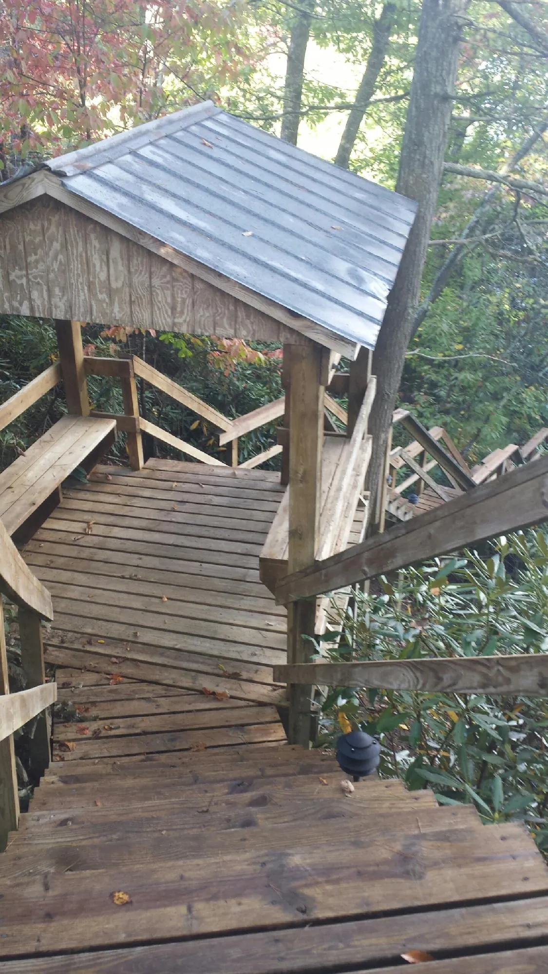 Metal roofed shelter over wooden steps on a wooded walkway — Skylight Repair & Installation work by our crew in Oil City
