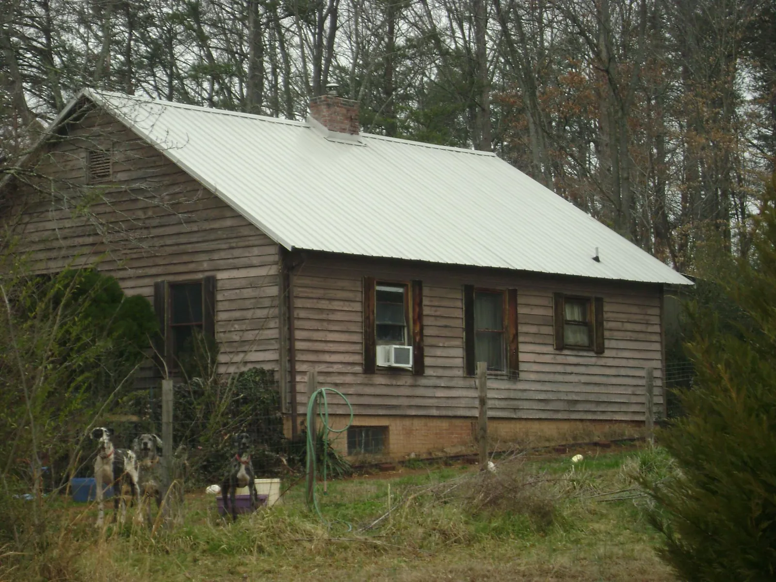 White metal roof on an old wood sided farmhouse, from a Metal Roof Installation job in Oil City